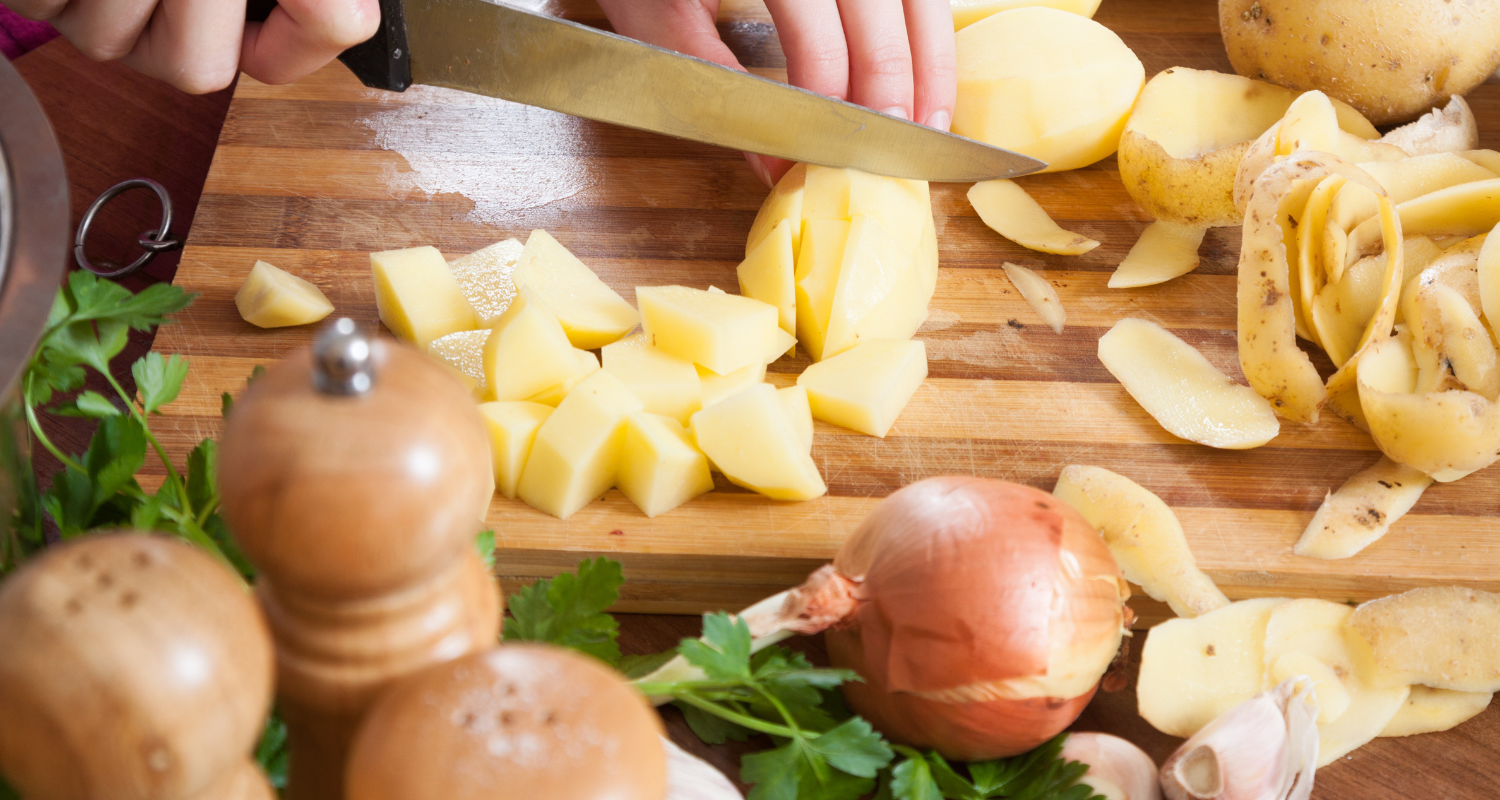 A close-up image showing hands mixing ingredients for potato sausage making.